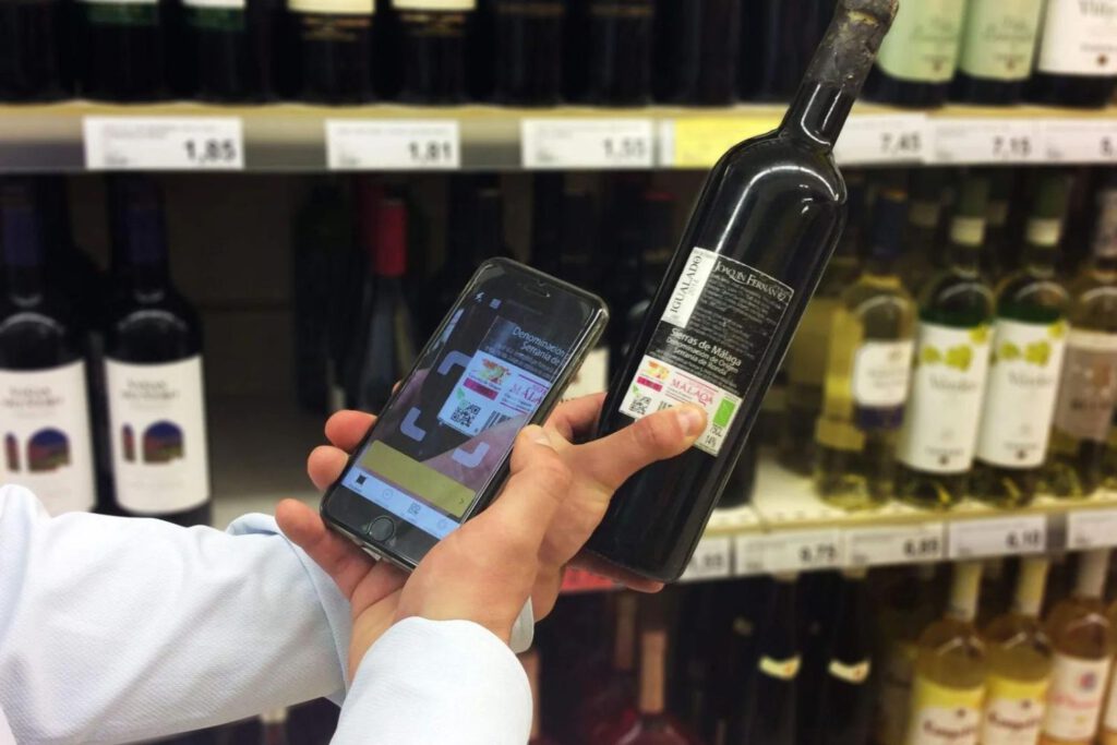 Hombre escaneando etiqueta de Naturcode en botella de vino