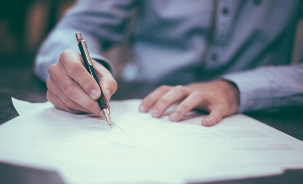 Hombre firmando reclamación de deudas entre empresas