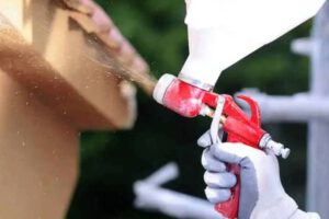 una pistola profesional proyectando una capa de corcho sobre la superficie de una fachada en rehabilitacion