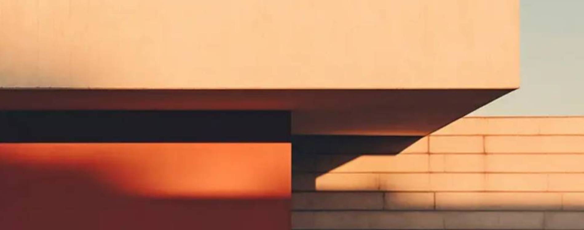 vista exterior de una vivienda de diseño moderno con revestimiento de corcho proyectado en tonos rojizos y arena