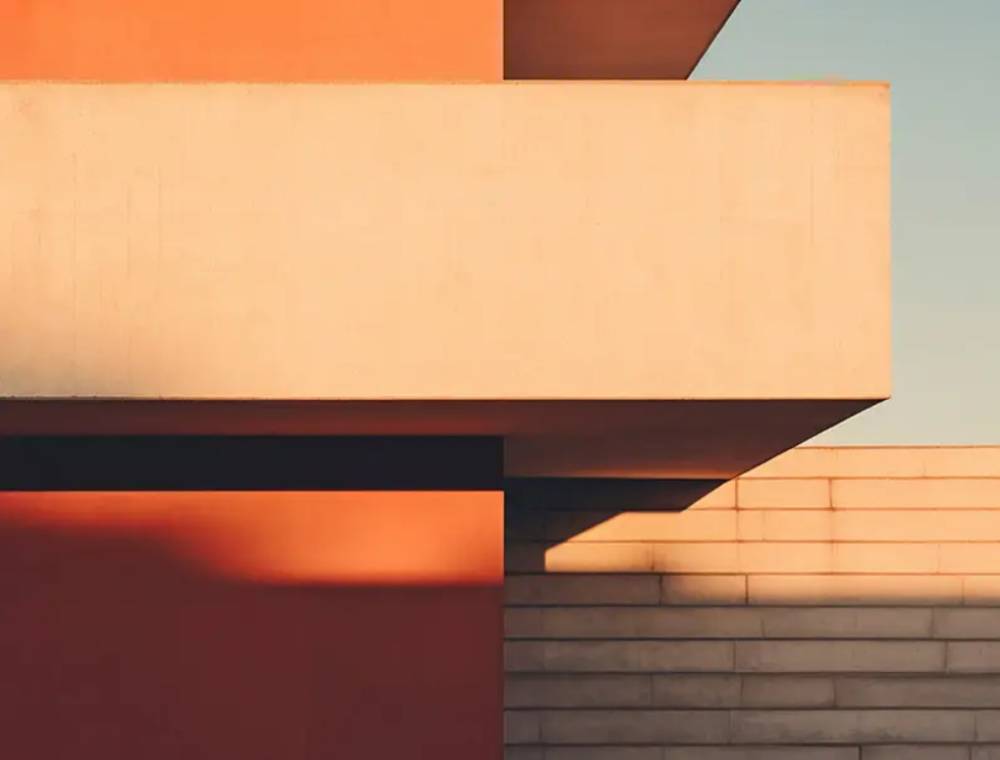 vista exterior de una vivienda de diseño moderno con revestimiento de corcho proyectado en tonos rojizos y arena